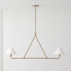 a brass chandelier with three white lamps hanging from it