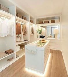 an instagram photo of a white closet with clothes on the shelves and lights in the ceiling