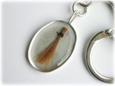 a keychain with a tassel hanging from it's side on a white surface