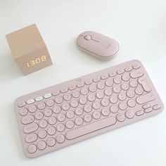 a pink keyboard and mouse on a white surface with a box for the word b o e