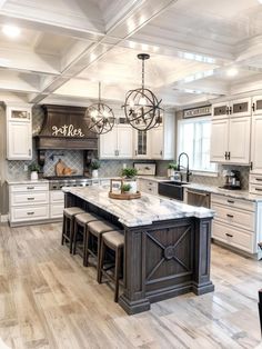 a large kitchen with white cabinets and marble counter tops