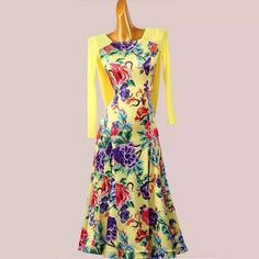 a dress on a mannequin with yellow sleeves and colorful flowers in the front