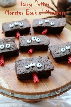 some brownies with googly eyes are on a wooden board and there is text overlay that says harry potter monster book of monsters