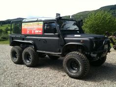 a black truck parked on top of a gravel road