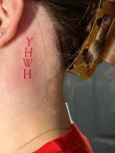 a woman with a tattoo on her neck that reads yhwh behind her ear