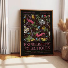 a poster is on the floor next to a vase with flowers and plants in it