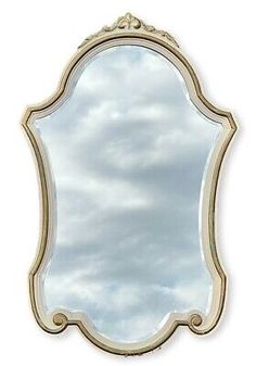 a large mirror with an ornate frame and gold trimmings on the edges, against a white background