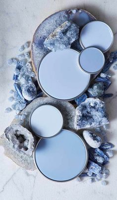 three empty plates sitting on top of a rock next to some rocks and ice crystals