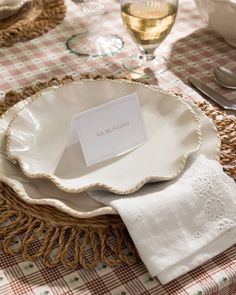 a table setting with place cards and napkins on it, along with wine glasses