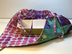 a colorful bag sitting on top of a table next to a white plate and bowl