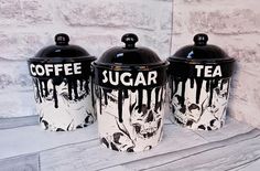 three coffee canisters sitting on top of a wooden table