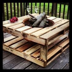 an outdoor table made out of wooden pallets with wine glasses and fruit on top