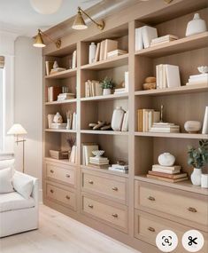 a living room filled with lots of furniture and bookshelves covered in white bookcases