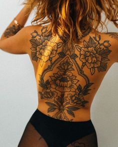 the back of a woman with tattoos on her body