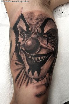 a close up of a person's leg with a tattoo on it and a clown face