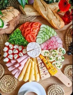 an assortment of cheeses, meats and vegetables arranged in a circle on a table