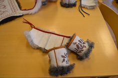 two pairs of slippers sitting on top of a wooden table next to other items