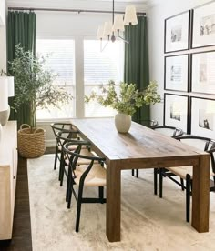 a dining room table with chairs and pictures on the wall