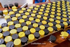 a table topped with lots of yellow and black cupcakes