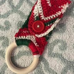 a red and white knitted hat with a wooden ring