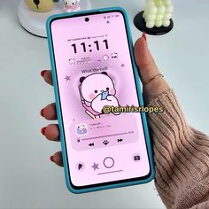 a person holding an iphone with a cartoon character on the screen and ear buds attached to it