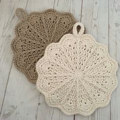 two crocheted doily sitting on top of a white wooden floor next to each other