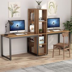 a computer desk with two monitors and a bookcase in front of a plant on the floor