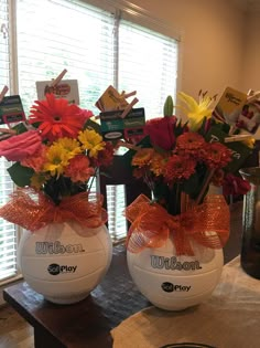 two vases filled with flowers sitting on top of a table next to each other