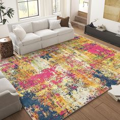 a living room with white couches and colorful rug