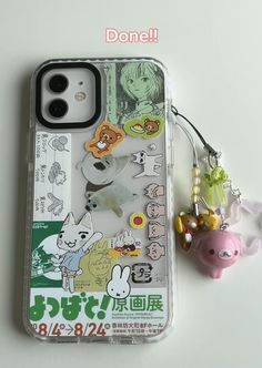 an iphone case with various stickers on it and a keychain attached to the back