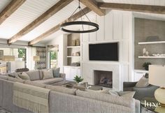 a living room filled with furniture and a flat screen tv mounted on the wall above a fireplace