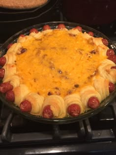 a pie with hot dogs in it sitting on top of an oven burner, ready to be baked