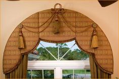 an arched window with curtains and tassels