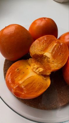 some oranges are sitting on top of a white plate