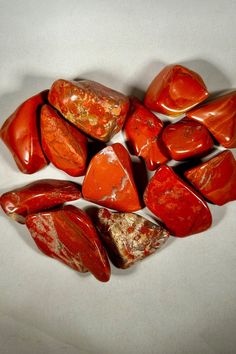 several red rocks are arranged on a white surface