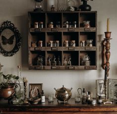 an old wooden shelf filled with lots of jars and other items on top of a table