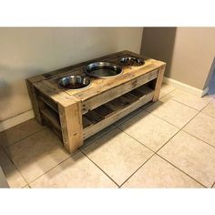 a dog bowl stand made out of pallet wood with two bowls on the top