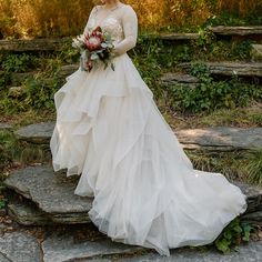 a woman in a wedding dress standing on some steps