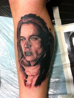 a woman's leg with a tattoo on it that has an image of her face