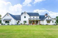 a large white house sitting on top of a lush green field