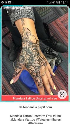 a woman's hand with an intricate tattoo on it