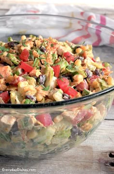 a glass bowl filled with salad on top of a wooden table