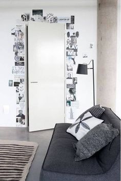 a black and white living room with lots of pictures on the wall behind the couch