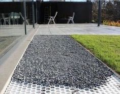 there is a black and white walkway in front of a building with glass doors on it