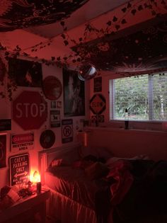 a bedroom with red lights and posters on the wall