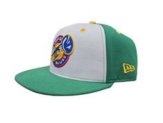 a green and white baseball cap with patches on it's front, sitting against a white background