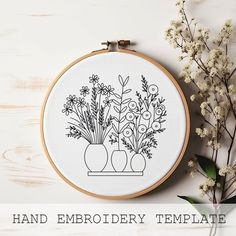 the embroidery pattern has three vases with flowers in them on a white table next to some branches