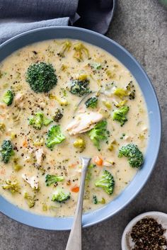 a bowl of broccoli and chicken soup with a spoon next to the bowl