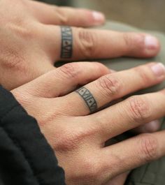 two hands with tattoos on their fingers