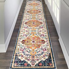 a long hallway with an ornate rug on the floor